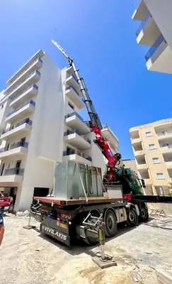 Ανύψωση γυάλινων επιφανειών με γερανό σε όροφο πολυκατοικίας υπό κατασκευή
