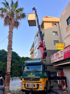 Καλαθοφόρο όχημα με ανυψωμένη πλατφόρμα εργασίας σε πρόσοψη κτηρίου