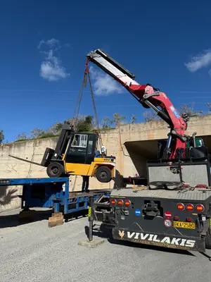 Ανύψωση κλαρκ με γερανό για φόρτωση σε πλατφόρμα μεταφοράς μηχανημάτων